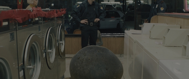 Wide shot frame from Everything Everywhere All at Once — standing, room, hat