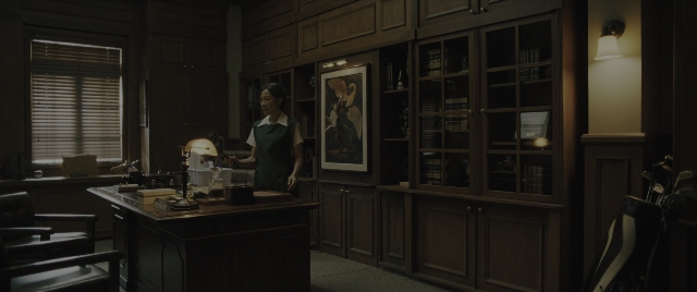 Wide shot frame from Everything Everywhere All at Once — desk, standing, room