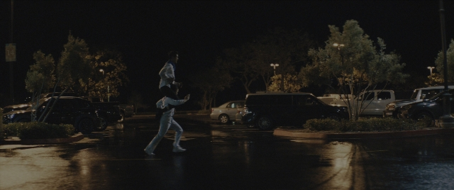Wide shot frame from Everything Everywhere All at Once — walking, street, car