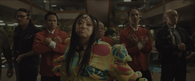 Wide shot frame from Everything Everywhere All at Once — standing, room, face