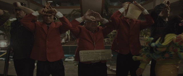 Wide shot frame from Everything Everywhere All at Once — standing, room, face