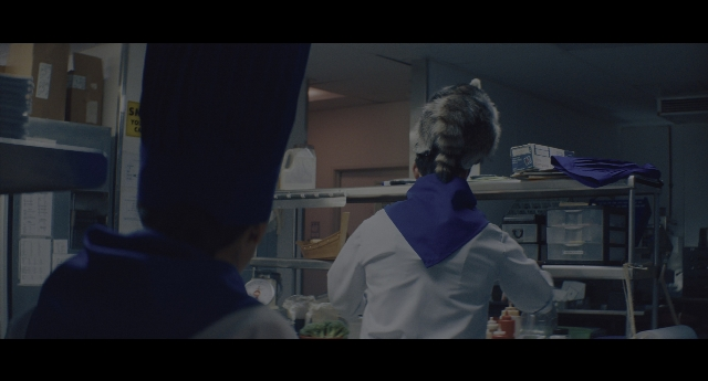 Wide shot frame from Everything Everywhere All at Once — standing, room, coat
