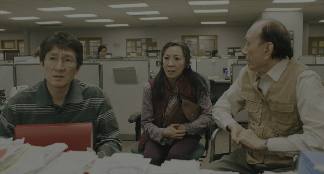 Wide shot frame from Everything Everywhere All at Once — sitting, shirt, office