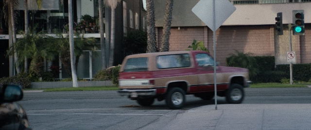Wide shot frame from The Way Back — street, car, truck