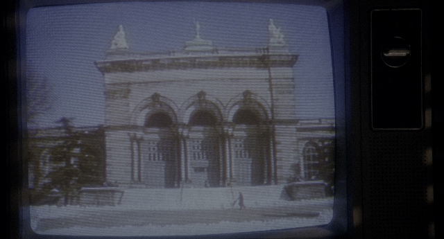 Wide shot frame from Twelve Monkeys — television, snow, building