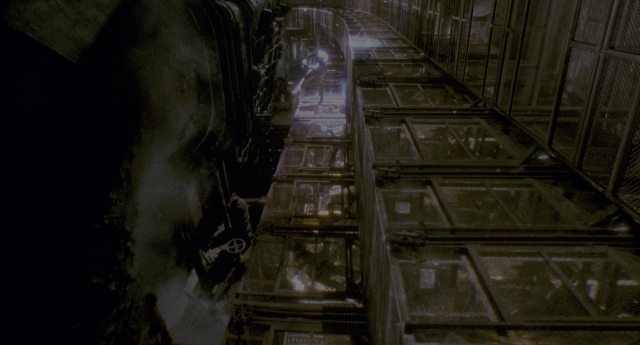 Wide shot frame from Twelve Monkeys — glass, pipe, running