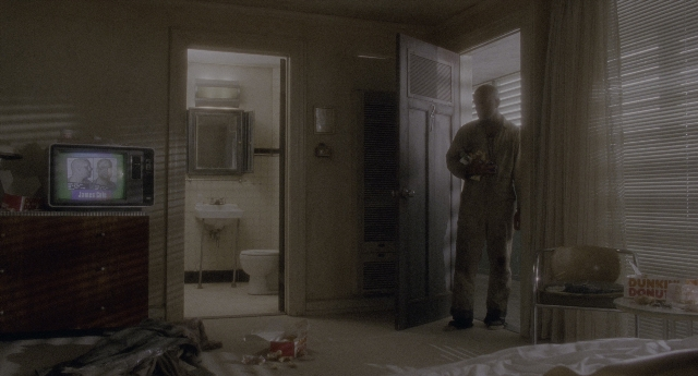 Wide shot frame from Twelve Monkeys — standing, bed, suit