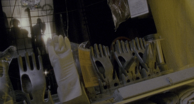 Wide shot frame from Twelve Monkeys — glove, person, window