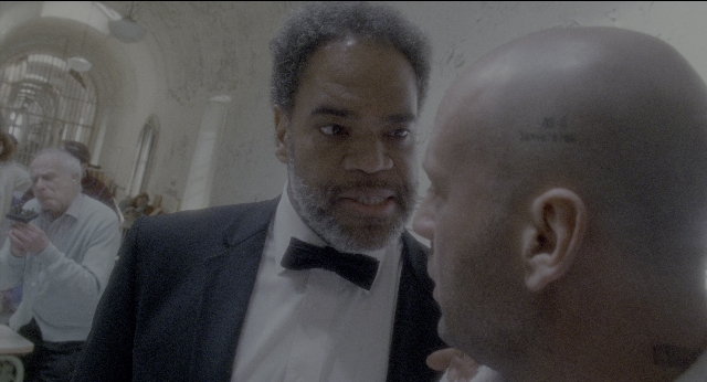 Medium shot frame from Twelve Monkeys — room, dialogue, suit