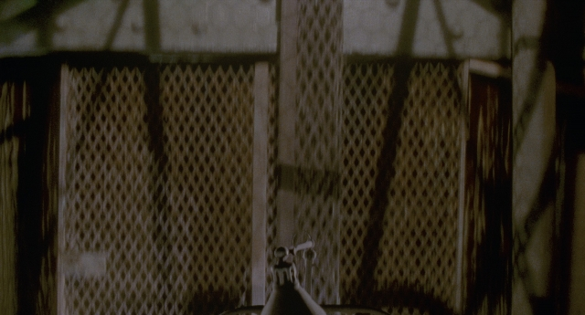 Wide shot frame from Twelve Monkeys — room, table, lamp