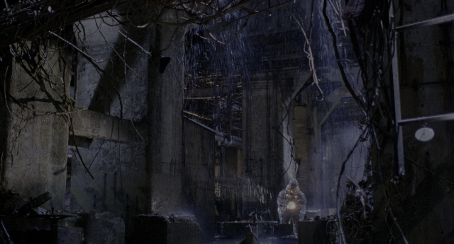 Wide shot frame from Twelve Monkeys — standing, person, building
