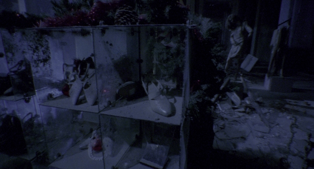 Wide shot frame from Twelve Monkeys — room, glass, bag
