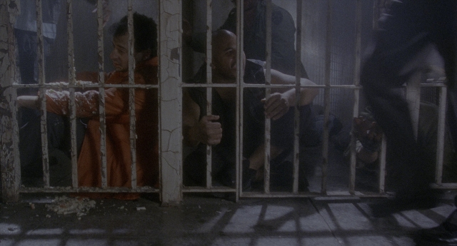 Wide shot frame from Twelve Monkeys — standing, hand, person