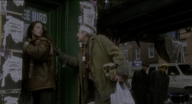 Wide shot frame from Twelve Monkeys — standing, street, hat