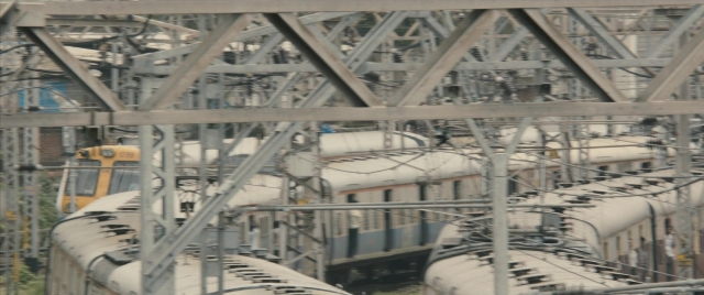 Wide shot frame from The Lunchbox — train, person, running