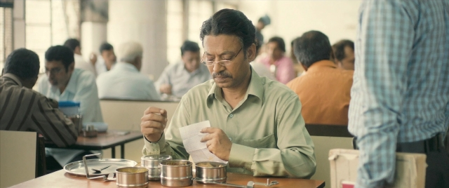 Wide shot frame from The Lunchbox — sitting, plate, table