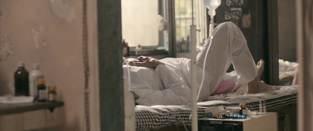 Wide shot frame from The Lunchbox — room, table, bed