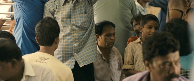 Wide shot frame from The Lunchbox — standing, room, train