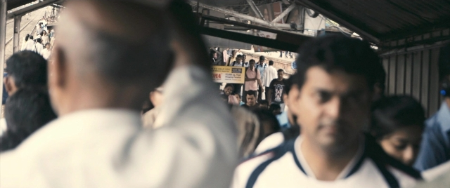 Medium shot frame from The Lunchbox — sitting, standing, shirt