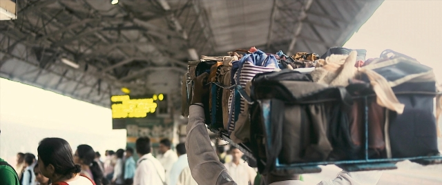 Wide shot frame from The Lunchbox — standing, train, person