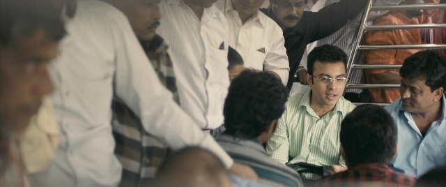Wide shot frame from The Lunchbox — sitting, shirt, train