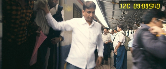 Wide shot frame from The Lunchbox — standing, dialogue, shirt