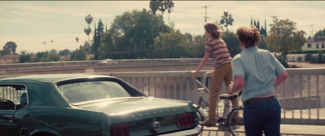 Frame from Licorice Pizza — standing, dialogue, car
