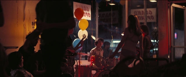 Wide shot frame from Licorice Pizza — room, drum, person