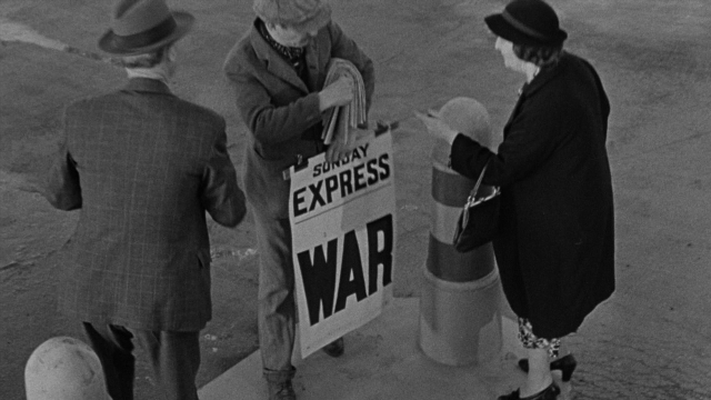 Wide shot frame from Foreign Correspondent — standing, dialogue, street