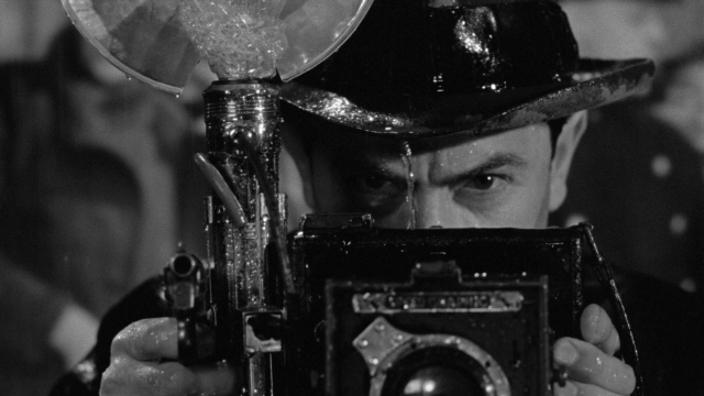 Wide shot frame from Foreign Correspondent — room, hat, face