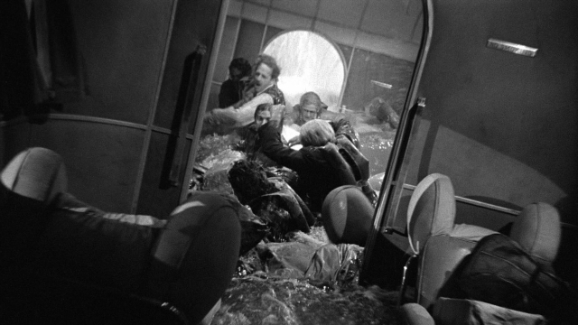 Wide shot frame from Foreign Correspondent — standing, car, train