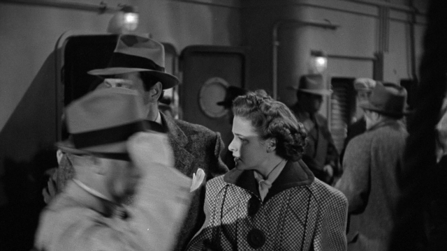 Wide shot frame from Foreign Correspondent — hat, coat, suit