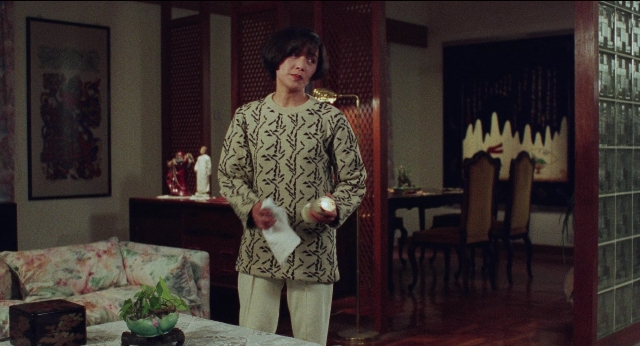 Wide shot frame from Fei lung mang jeung — standing, room, table