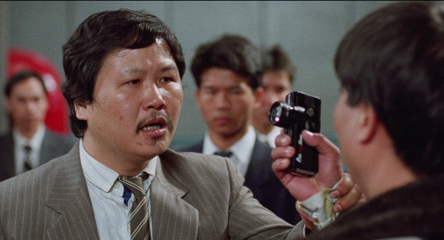 Medium shot frame from Fei lung mang jeung — standing, room, dialogue