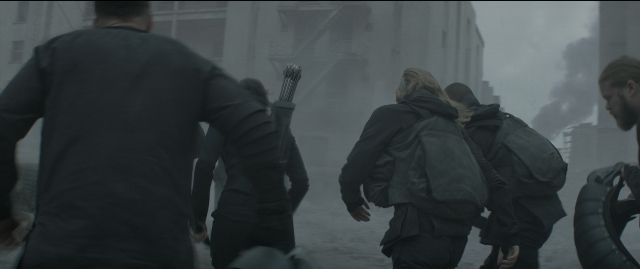 Medium shot frame from The Hunger Games: Mockingjay - Part 1 — walking, street, smoke