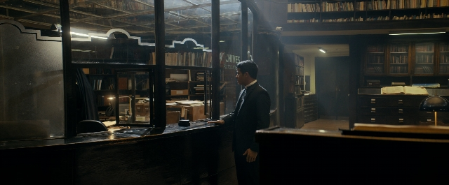 Wide shot frame from Prey for the Devil — desk, book, standing