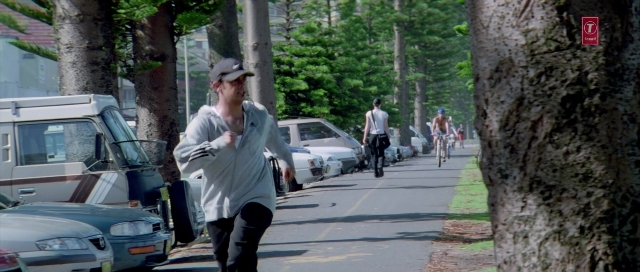 Wide shot frame from Zärtliche Begierde — walking, street, hat
