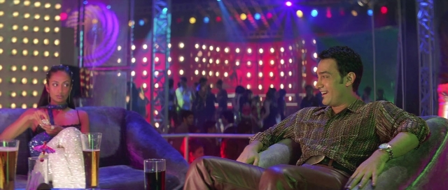 Wide shot frame from Zärtliche Begierde — sitting, table, dialogue