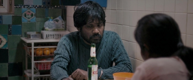 Wide shot frame from Dheepan — sitting, table, kitchen