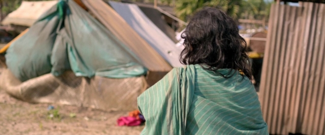 Frame from Dheepan — sitting, hair, person