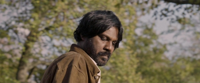 Frame from Dheepan — standing, beard, face