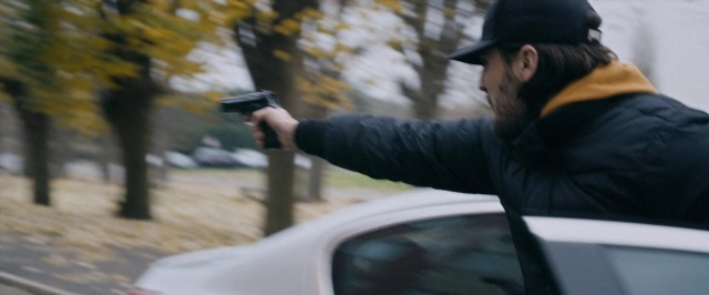 Wide shot frame from Dheepan — standing, street, hat