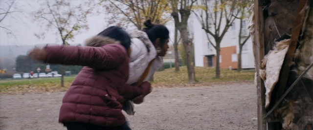 Wide shot frame from Dheepan — standing, bird, fight