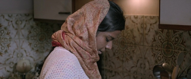 Wide shot frame from Dheepan — standing, phone, mirror