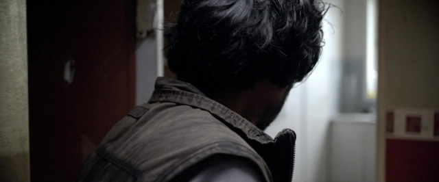 Wide shot frame from Dheepan — standing, door, shirt
