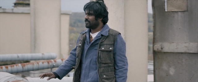 Frame from Dheepan — standing, jacket, beard