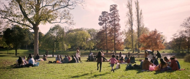 Wide shot frame from Dheepan — sitting, standing, dialogue