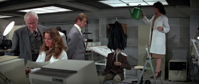 Wide shot frame from For Your Eyes Only — standing, room, coat