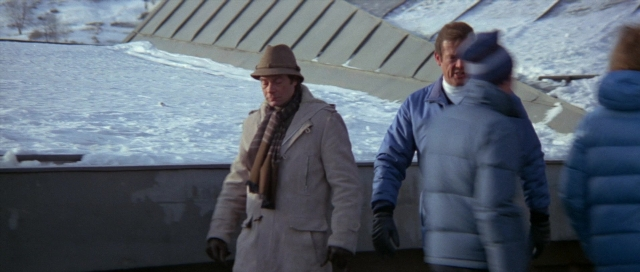 Wide shot frame from For Your Eyes Only — walking, hat, coat