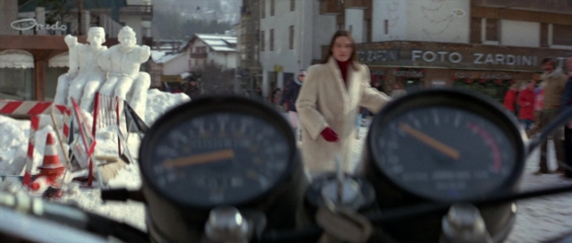 Wide shot frame from For Your Eyes Only — standing, street, coat